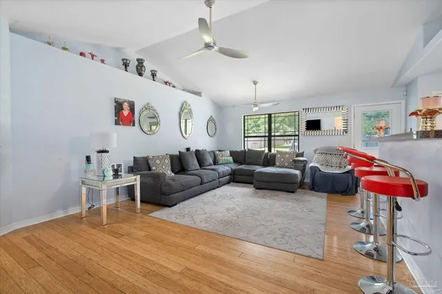 a living room with furniture kitchen view and a window