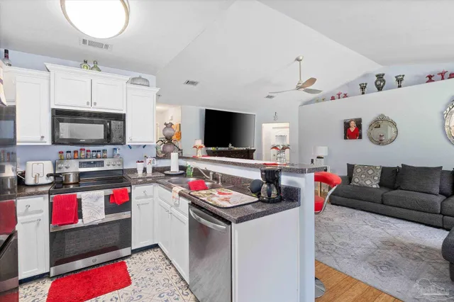 a living room with kitchen island furniture and a flat screen tv