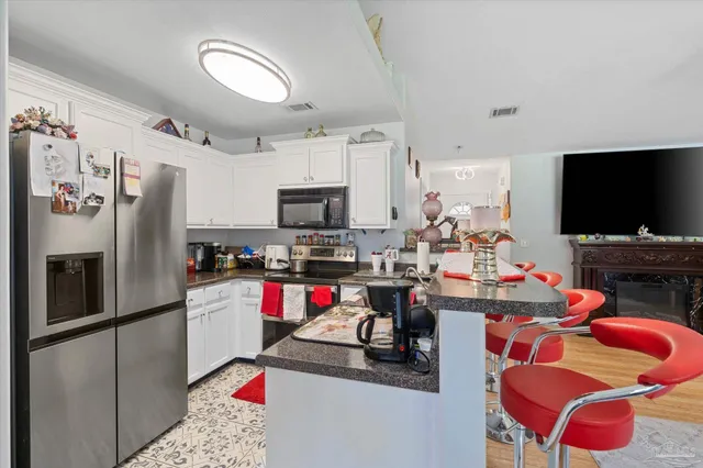 a kitchen with stainless steel appliances kitchen island granite countertop a refrigerator and a stove