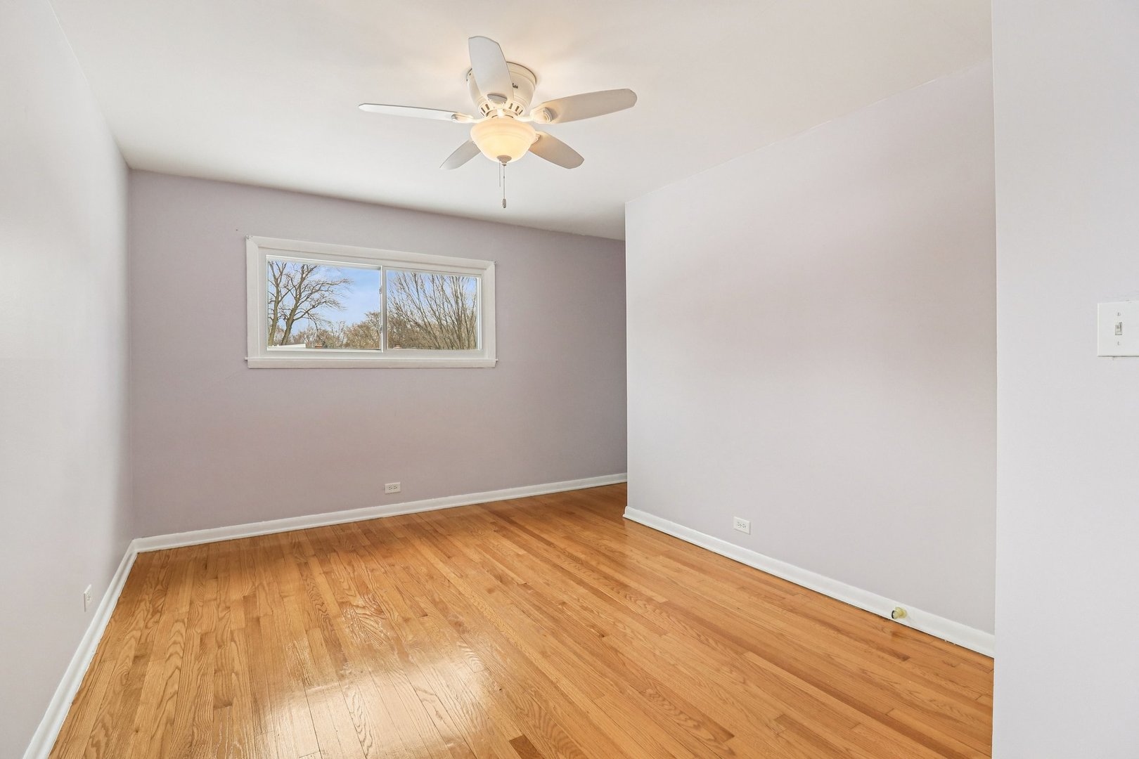 2931 Greenleaf Avenue Wilmette, IL 60091 - Photo 27 of 44 an empty room with wooden floor and ceiling fan