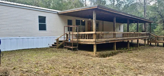 a view of a house with a yard and wooden fence