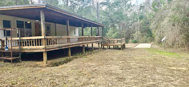 a view of a house with backyard and sitting area