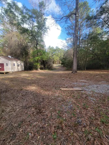 a view of a white house with a yard and garage