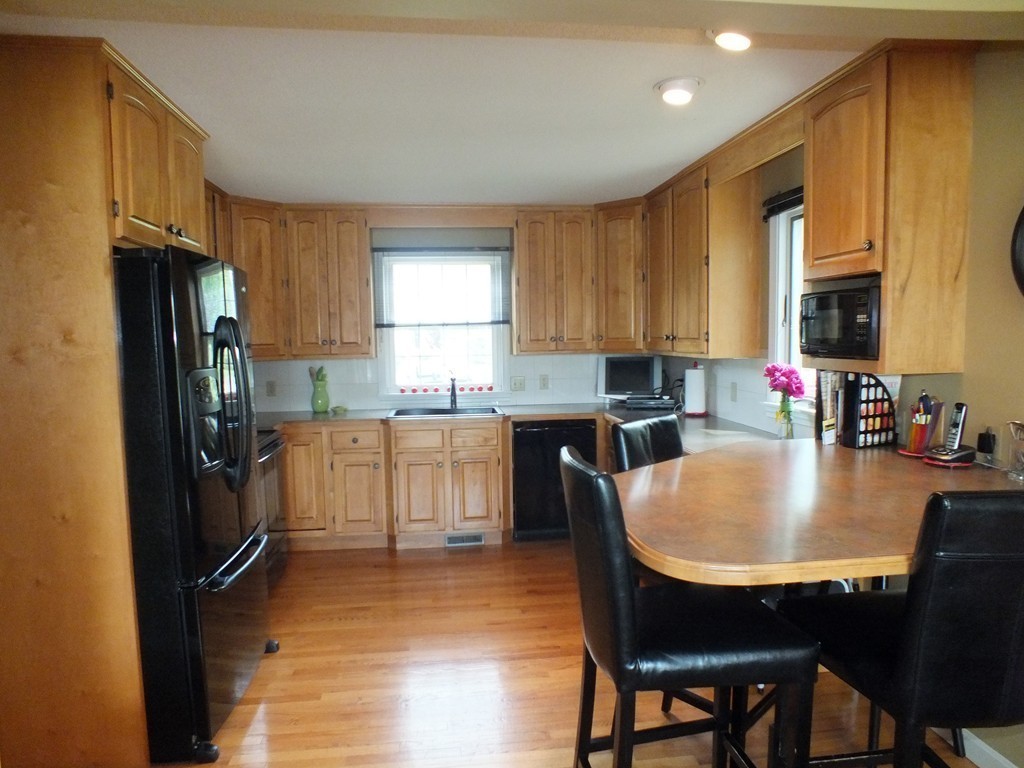 17 Orchard Road East Longmeadow, MA 01028 - Photo 11 of 30 a kitchen with granite countertop a refrigerator a stove a sink dishwasher a dining table and chairs with wooden floor
