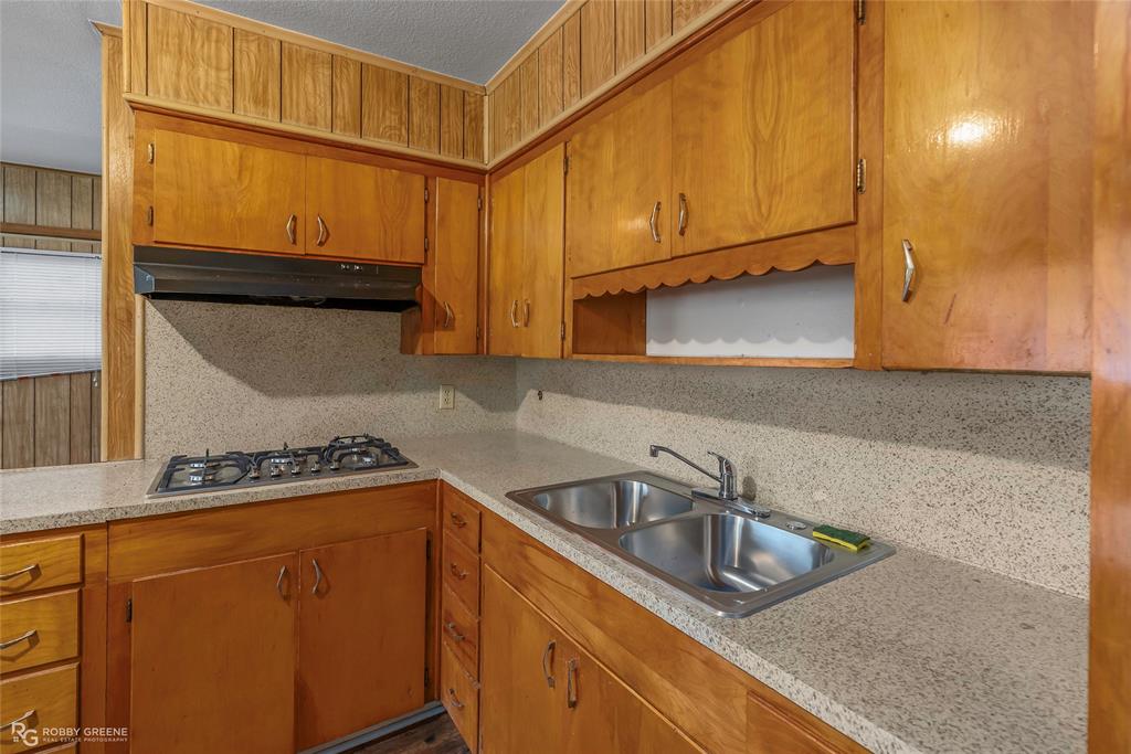 8321 Kingston Road Shreveport, LA 71108 - Photo 7 of 22 a kitchen with stainless steel appliances granite countertop a sink a stove and a microwave oven