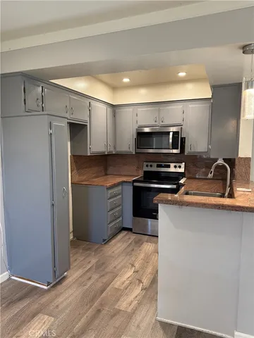 a kitchen with kitchen island a counter top space stainless steel appliances and cabinets