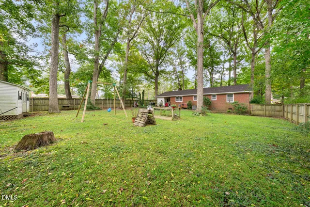 a view of a garden with potted plants and large trees