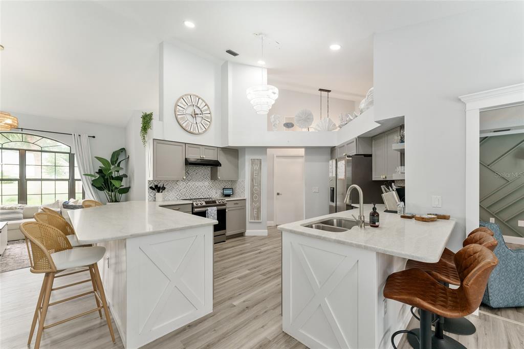 4841 Northwest 76th Court Ocala, FL 34482 - Photo 12 of 40 a kitchen with stainless steel appliances kitchen island granite countertop a stove a sink a dining table and chairs with wooden floor