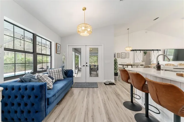 a living room with furniture a flat screen tv and a large window