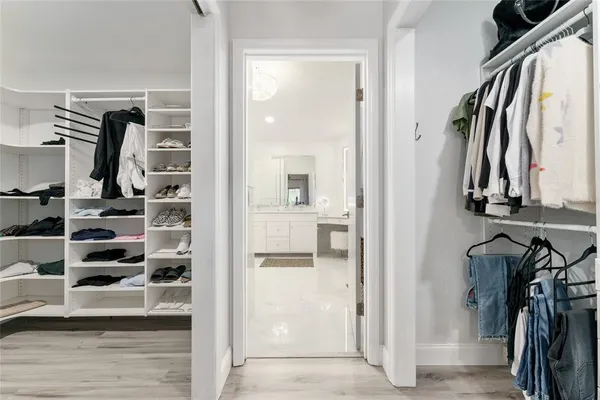 a view of walk in closet with clothes and shoes