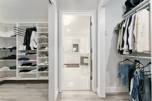 a view of walk in closet with clothes and shoes
