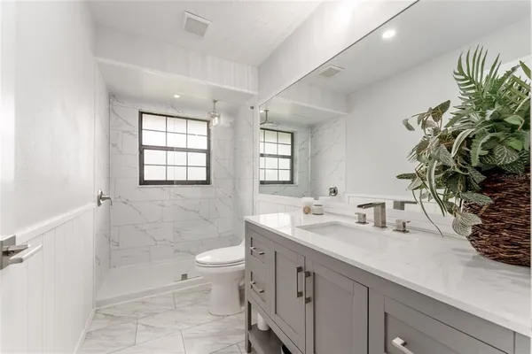 a bathroom with a double vanity sink toilet and shower