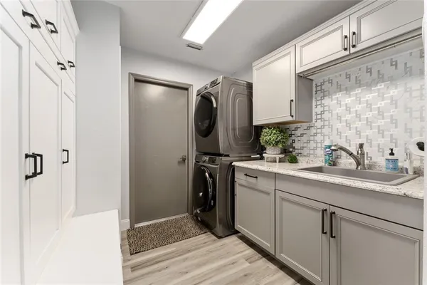 a bathroom with a sink a mirror a washer and dryer