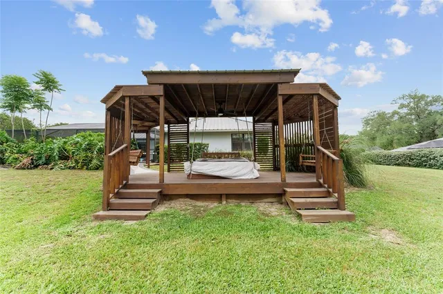 a view of house with backyard outdoor seating and green space