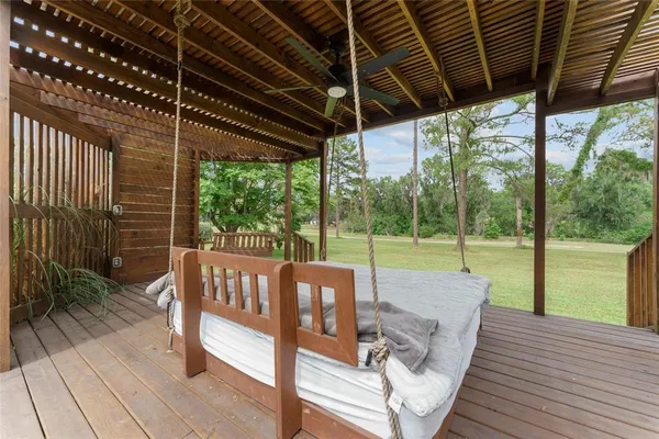 a view of a deck with wooden floor a yard tables and chairs