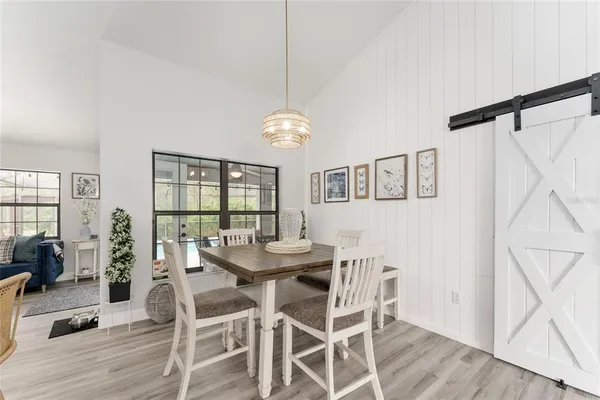 a dining room with furniture a chandelier and wooden floor