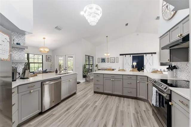 a large kitchen with a lot of counter space and wooden floor