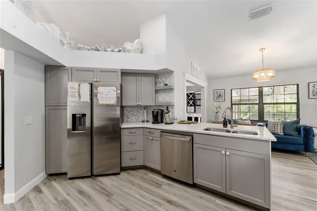 a kitchen with stainless steel appliances granite countertop a refrigerator sink and cabinets