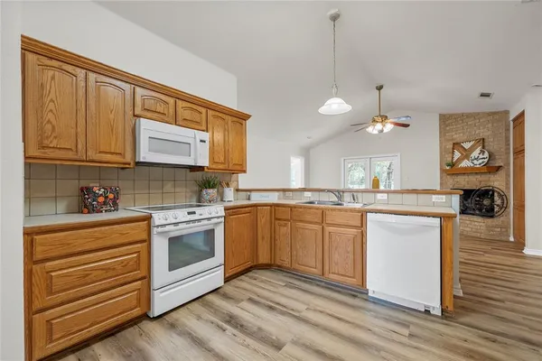 a kitchen with granite countertop cabinets stainless steel appliances and wooden floor