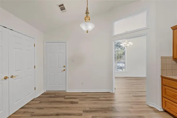 a large kitchen with a center island and wooden floor