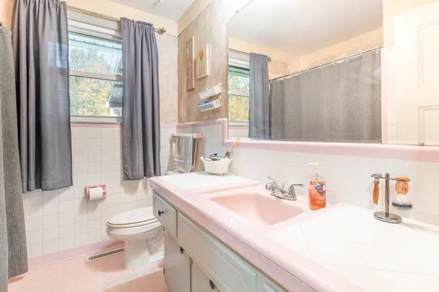 a bathroom with a sink toilet vanity and tub