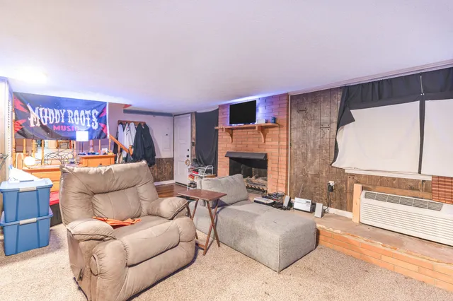 a living room with furniture a large window and a fireplace