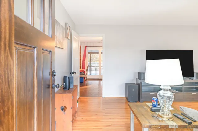a living room with furniture a flat screen tv and a table