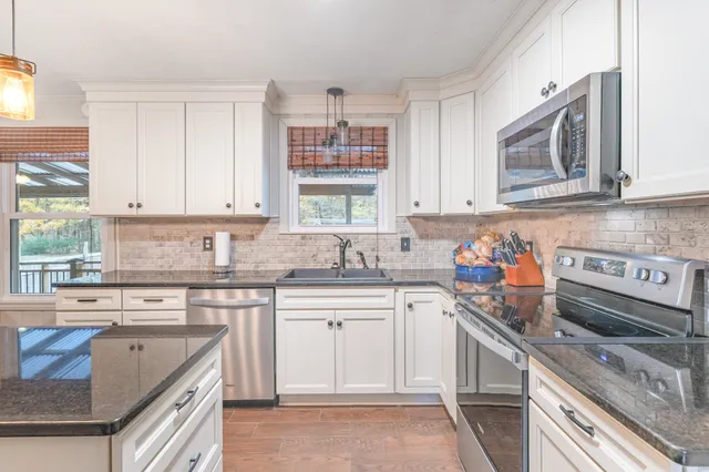 a kitchen with a sink stove top oven and microwave