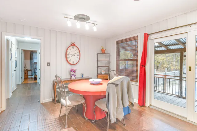 a dining room with wooden floor a glass table and chairs