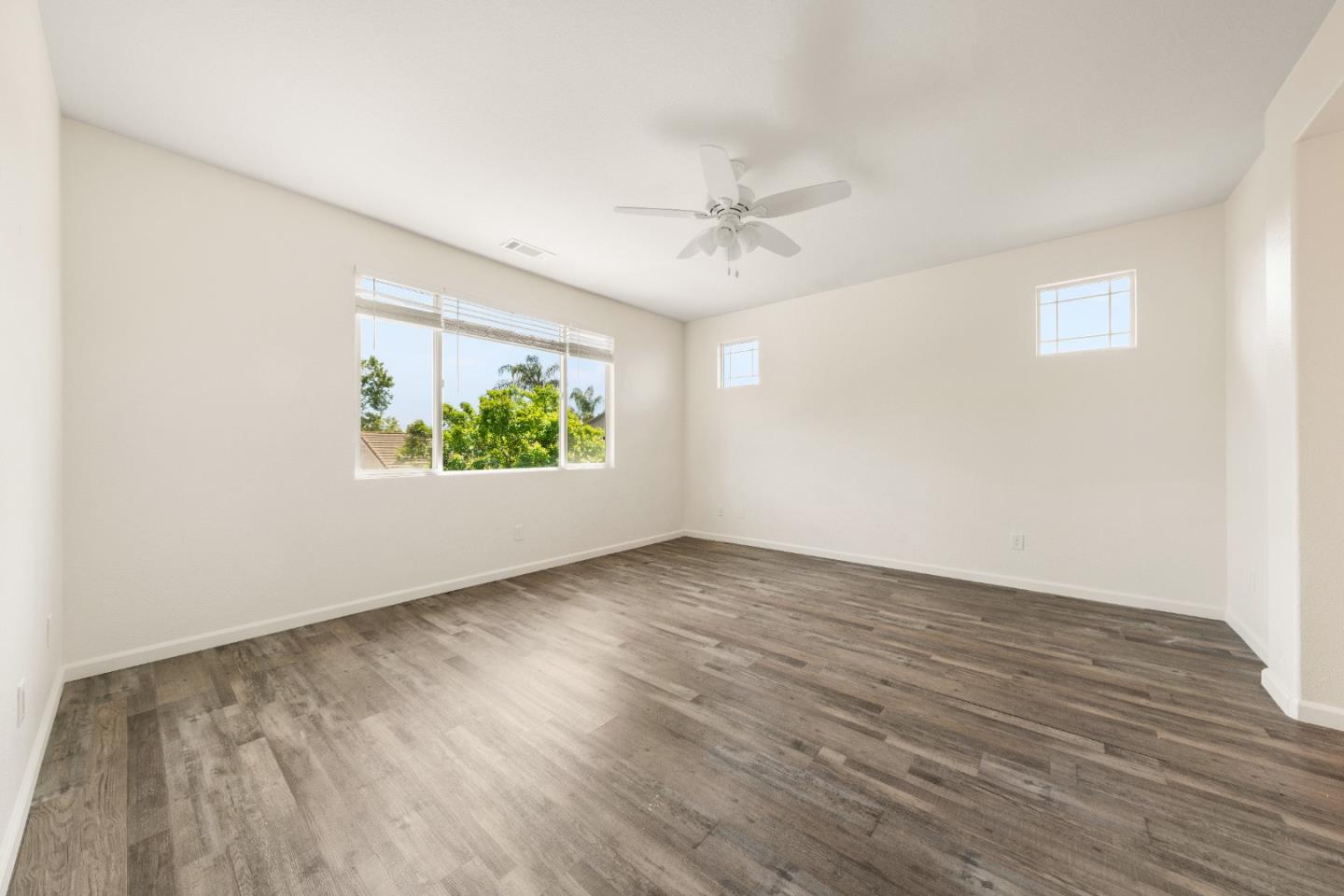 5700 Gold Poppy Way Elk Grove, CA 95757 - Photo 14 of 49 an empty room with wooden floor chandelier fan and windows