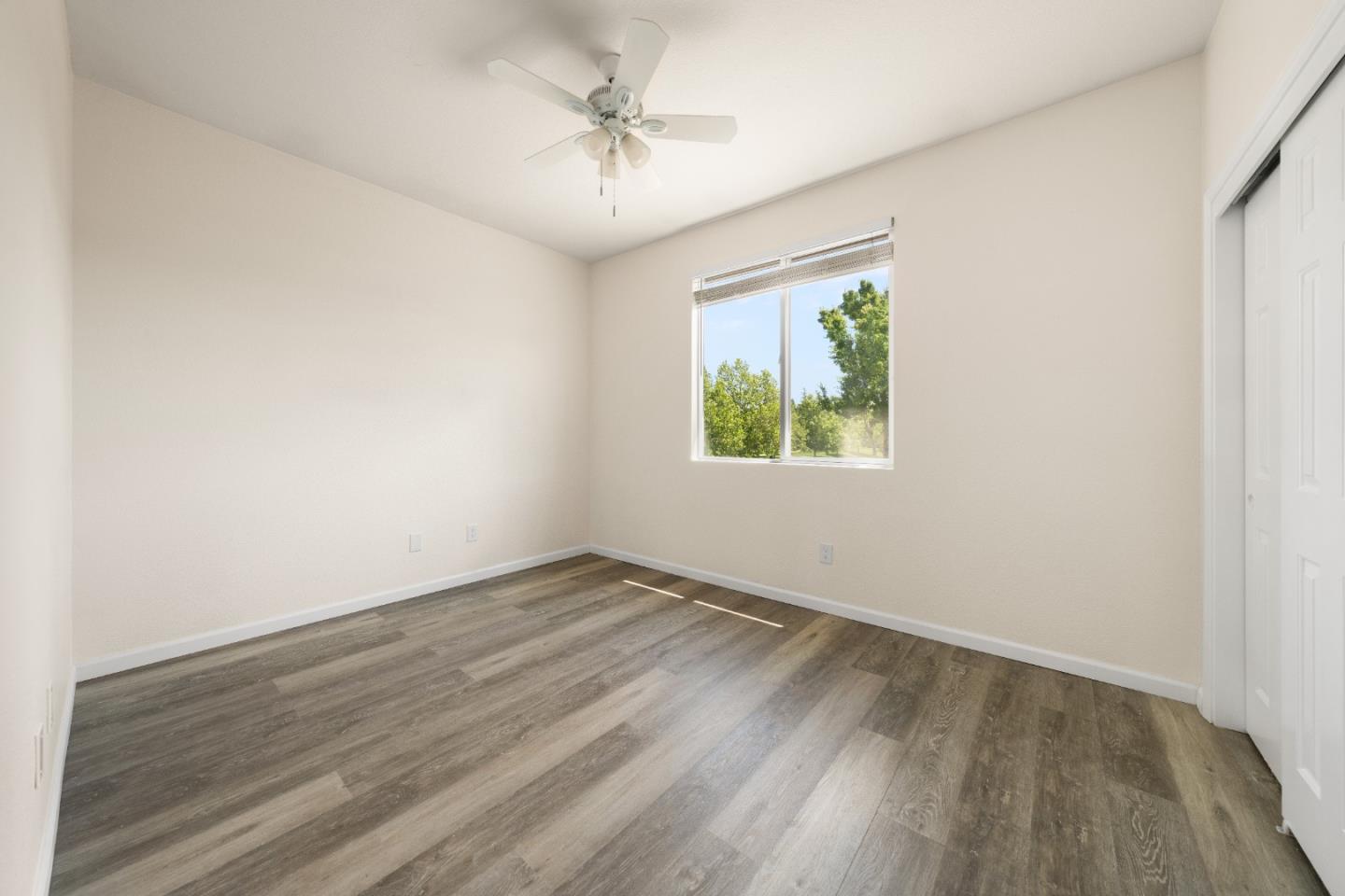 5700 Gold Poppy Way Elk Grove, CA 95757 - Photo 17 of 49 an empty room with wooden floor chandelier fan and windows