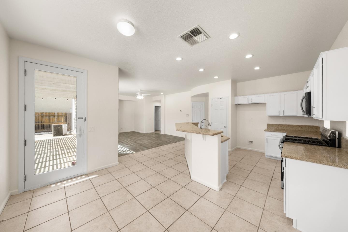 5700 Gold Poppy Way Elk Grove, CA 95757 - Photo 22 of 49 a large white kitchen with a white countertops a stove a dining table and chairs