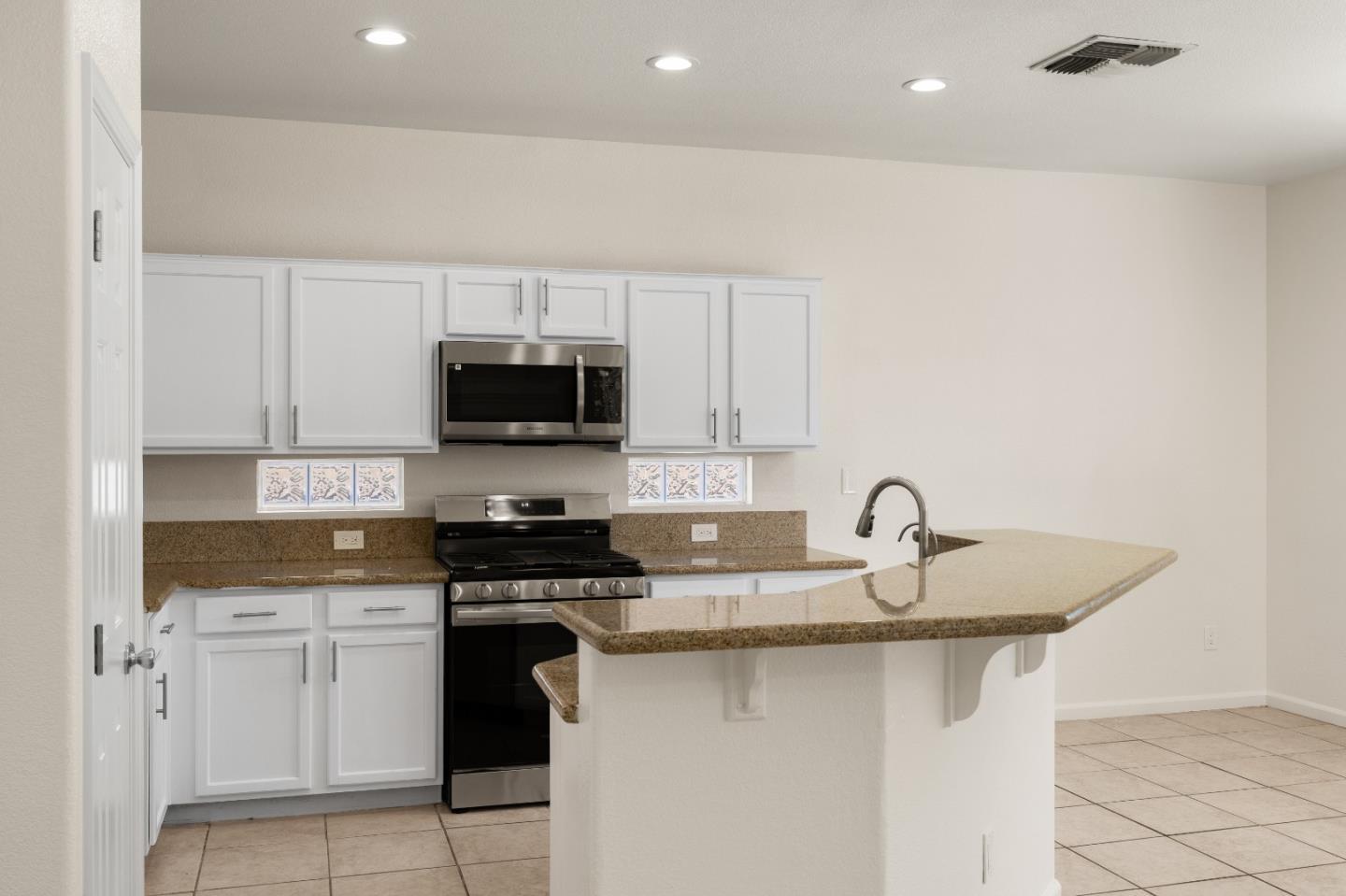 5700 Gold Poppy Way Elk Grove, CA 95757 - Photo 26 of 49 a kitchen with granite countertop a sink stainless steel appliances and white cabinets