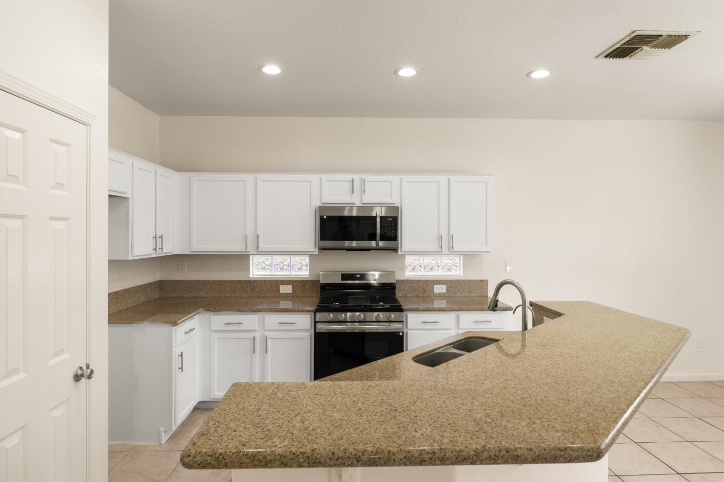 5700 Gold Poppy Way Elk Grove, CA 95757 - Photo 27 of 49 a kitchen with granite countertop a sink a stove and cabinets