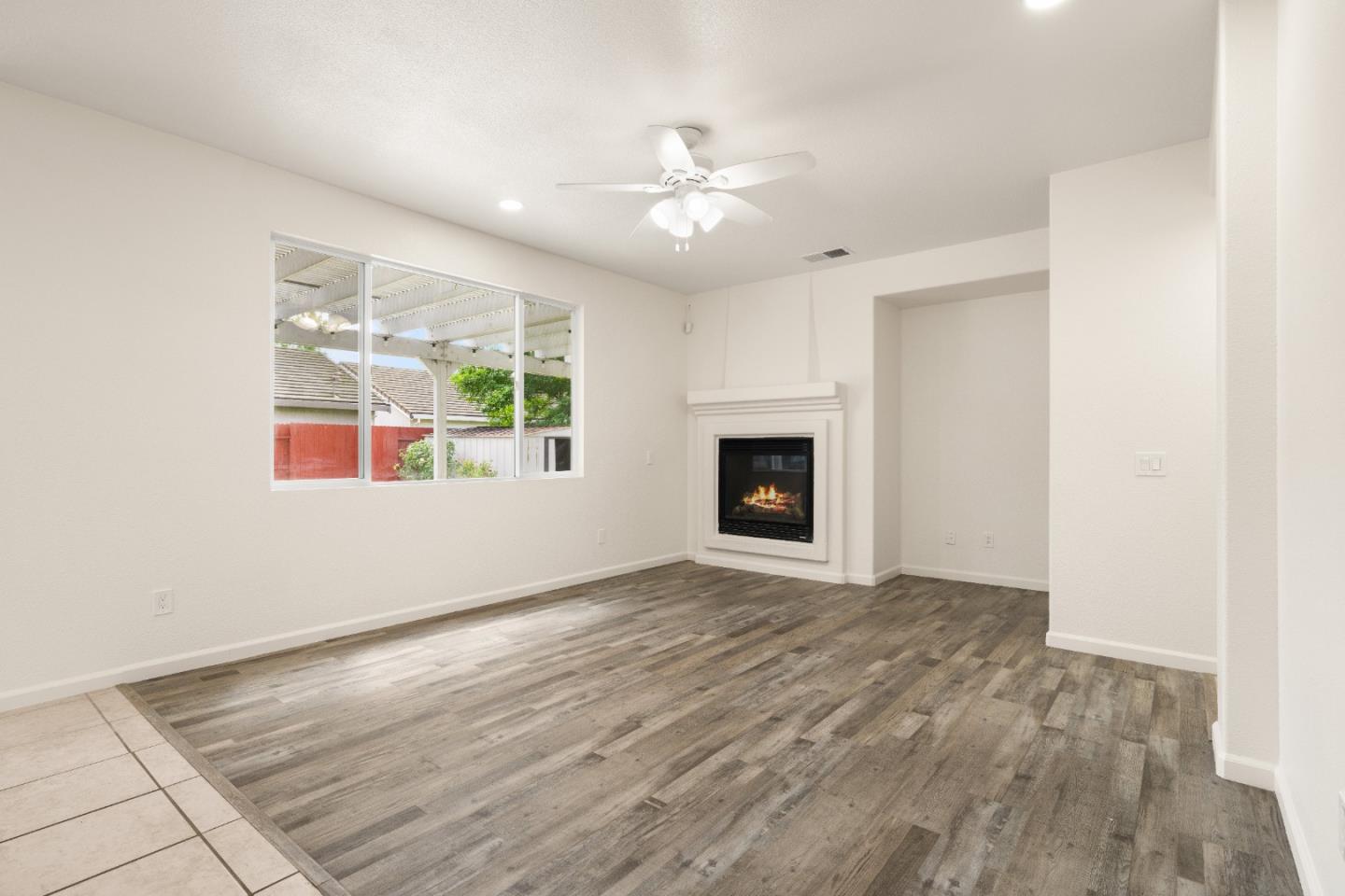 5700 Gold Poppy Way Elk Grove, CA 95757 - Photo 30 of 49 a view of an empty room with wooden floor fireplace and a window