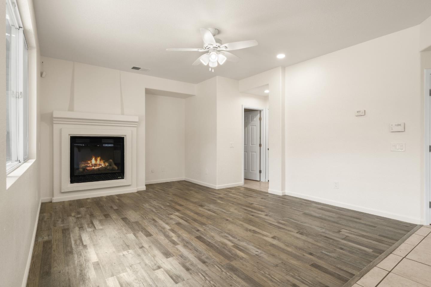 5700 Gold Poppy Way Elk Grove, CA 95757 - Photo 31 of 49 a view of an empty room with wooden floor fireplace and a window