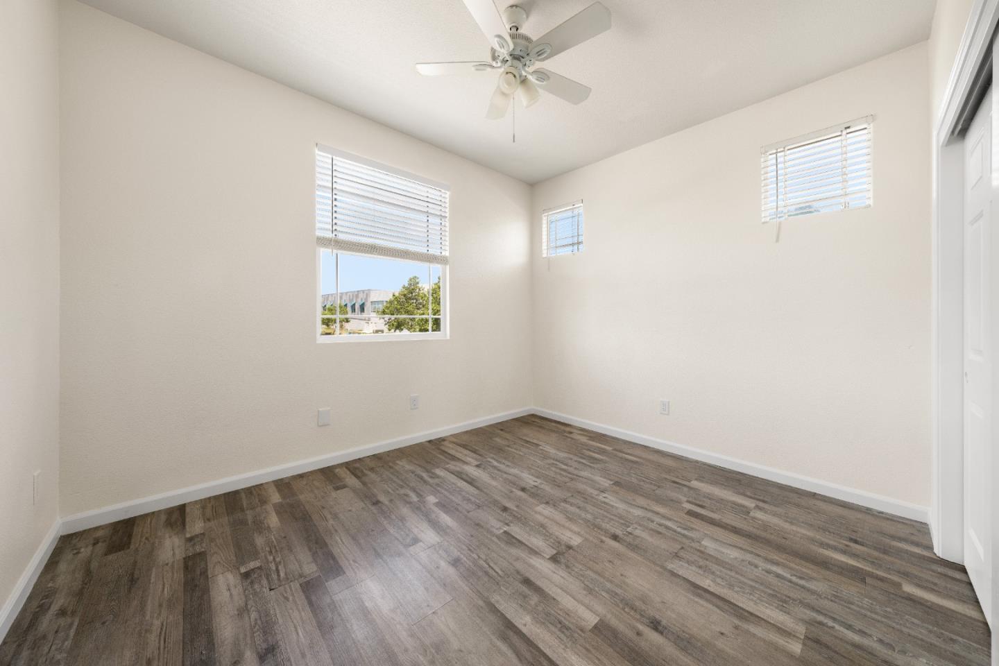 5700 Gold Poppy Way Elk Grove, CA 95757 - Photo 34 of 49 an empty room with wooden floor chandelier fan and windows