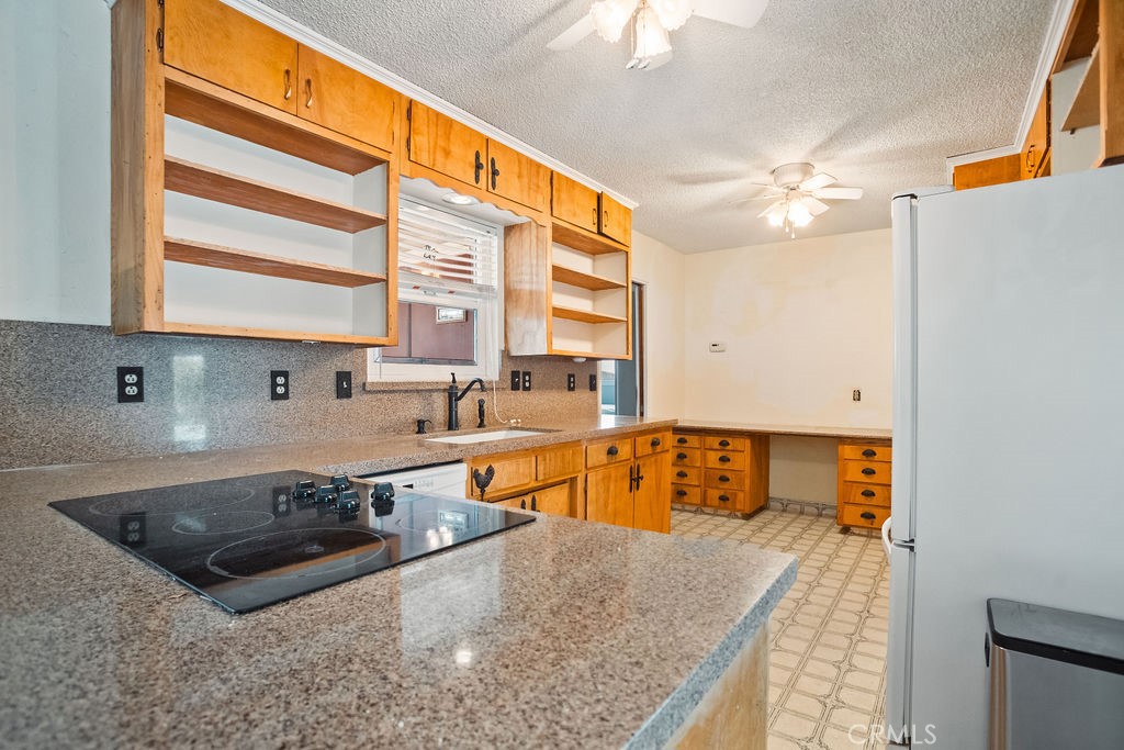 3046 El Capitan Avenue Merced, CA 95340 - Photo 3 of 18 a kitchen with a stove a sink and a refrigerator