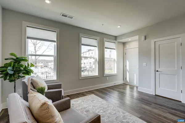 a living room with furniture and a dining table with wooden floor