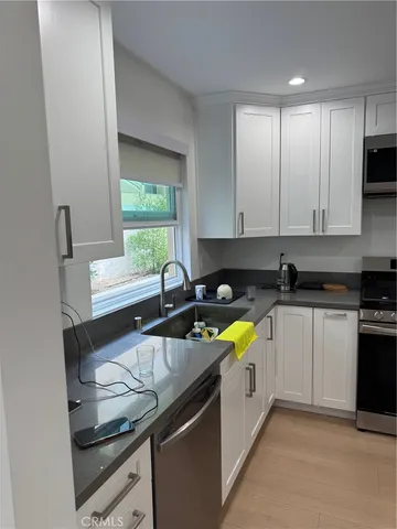 a kitchen with stainless steel appliances granite countertop a sink and a stove