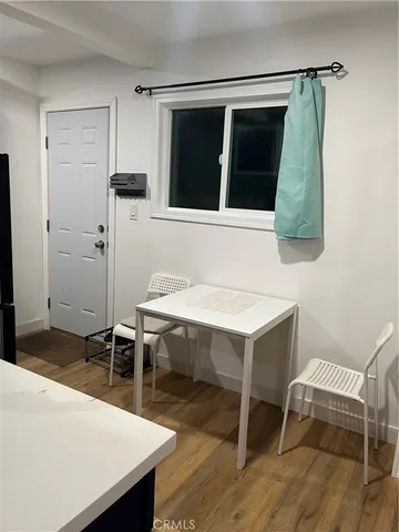 a bedroom with a refrigerator and a window