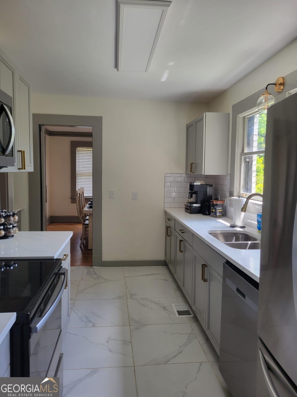 6127 Floyd Street Northeast Covington, GA 30014 - Photo 9 of 23 a kitchen with a sink stove and cabinets