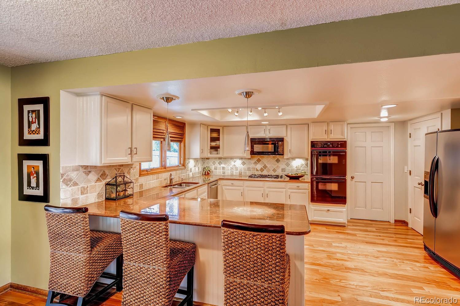 8110 Sweet Water Road Lone Tree, CO 80124 - Photo 13 of 34 a living room with stainless steel appliances kitchen island granite countertop furniture and a kitchen view