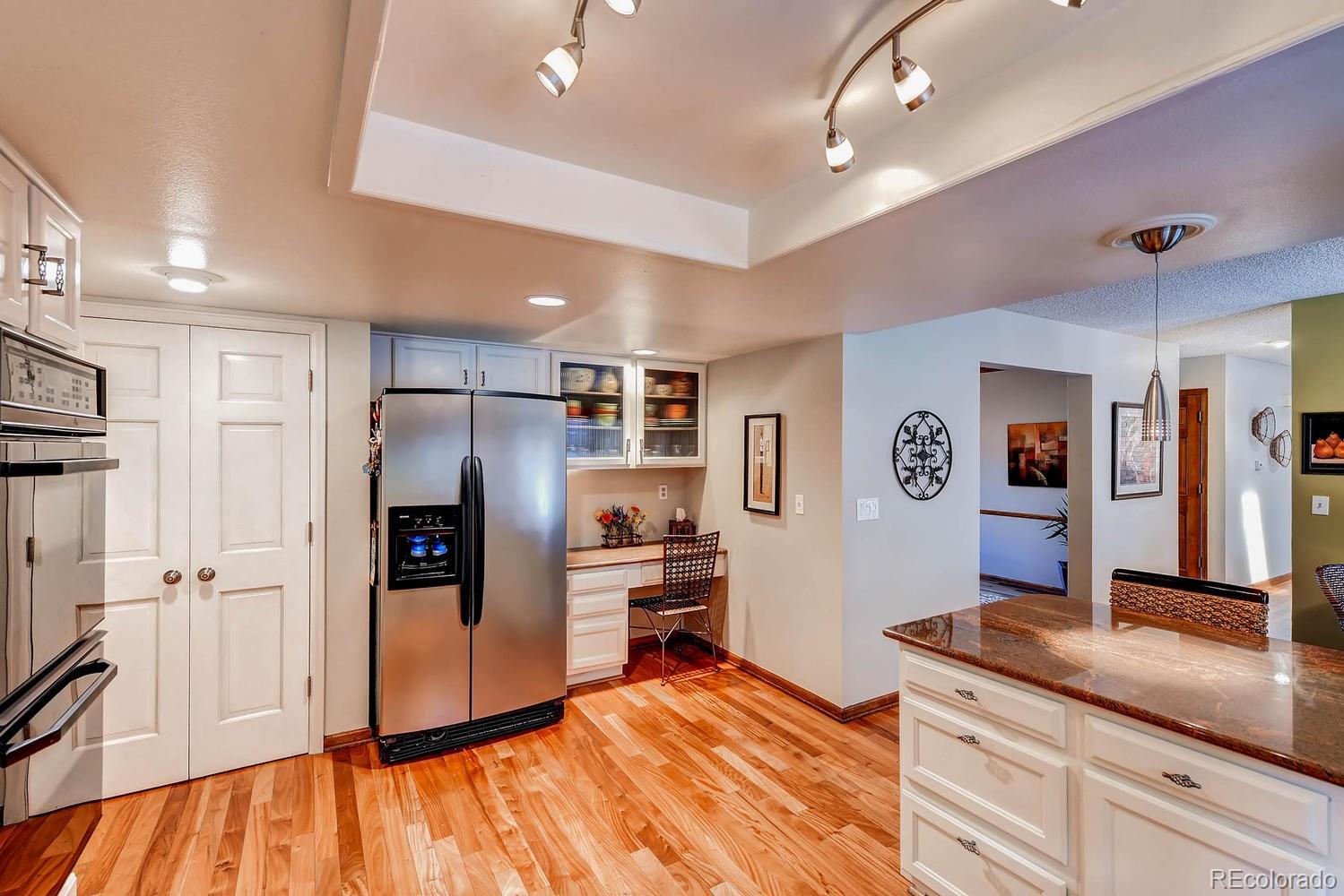 8110 Sweet Water Road Lone Tree, CO 80124 - Photo 16 of 34 a large kitchen with stainless steel appliances a refrigerator and a stove top oven
