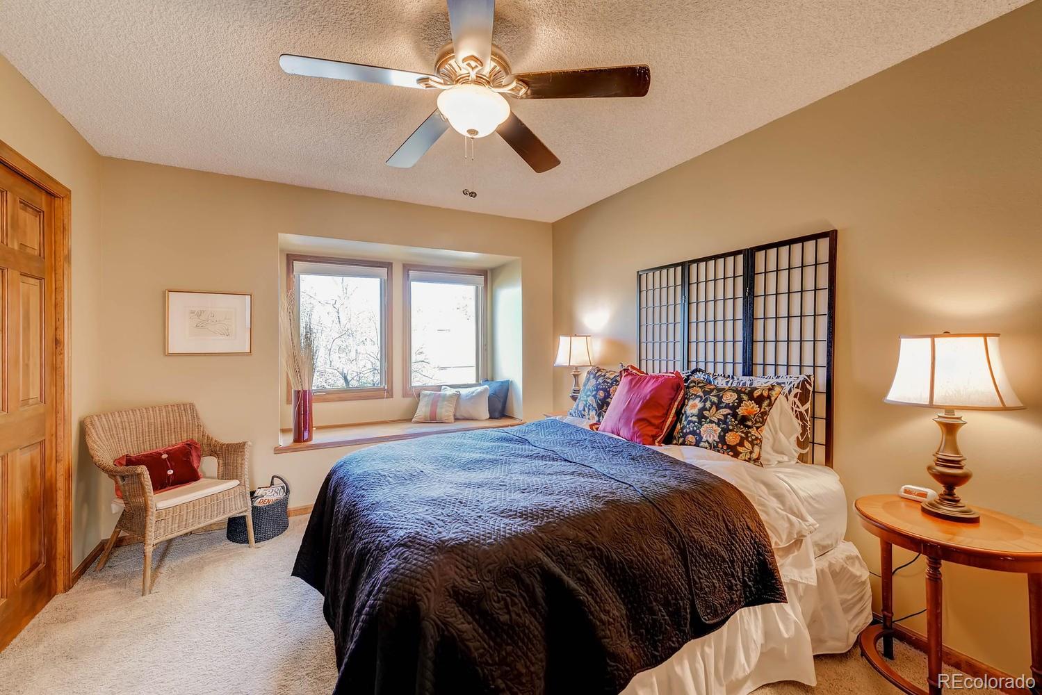 8110 Sweet Water Road Lone Tree, CO 80124 - Photo 21 of 34 a bedroom with a bed and a chandelier