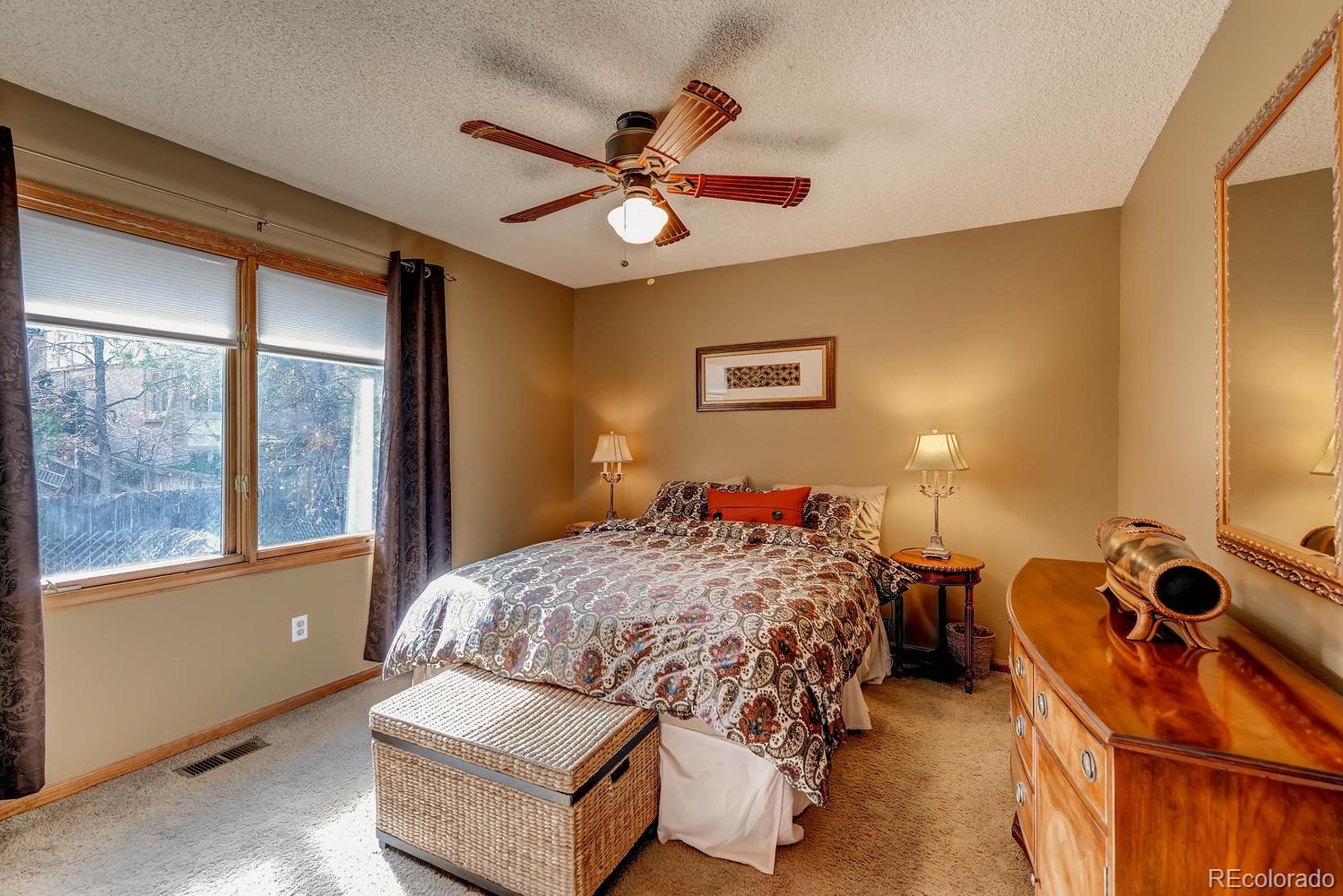 8110 Sweet Water Road Lone Tree, CO 80124 - Photo 22 of 34 a bedroom with a bed and a chandelier