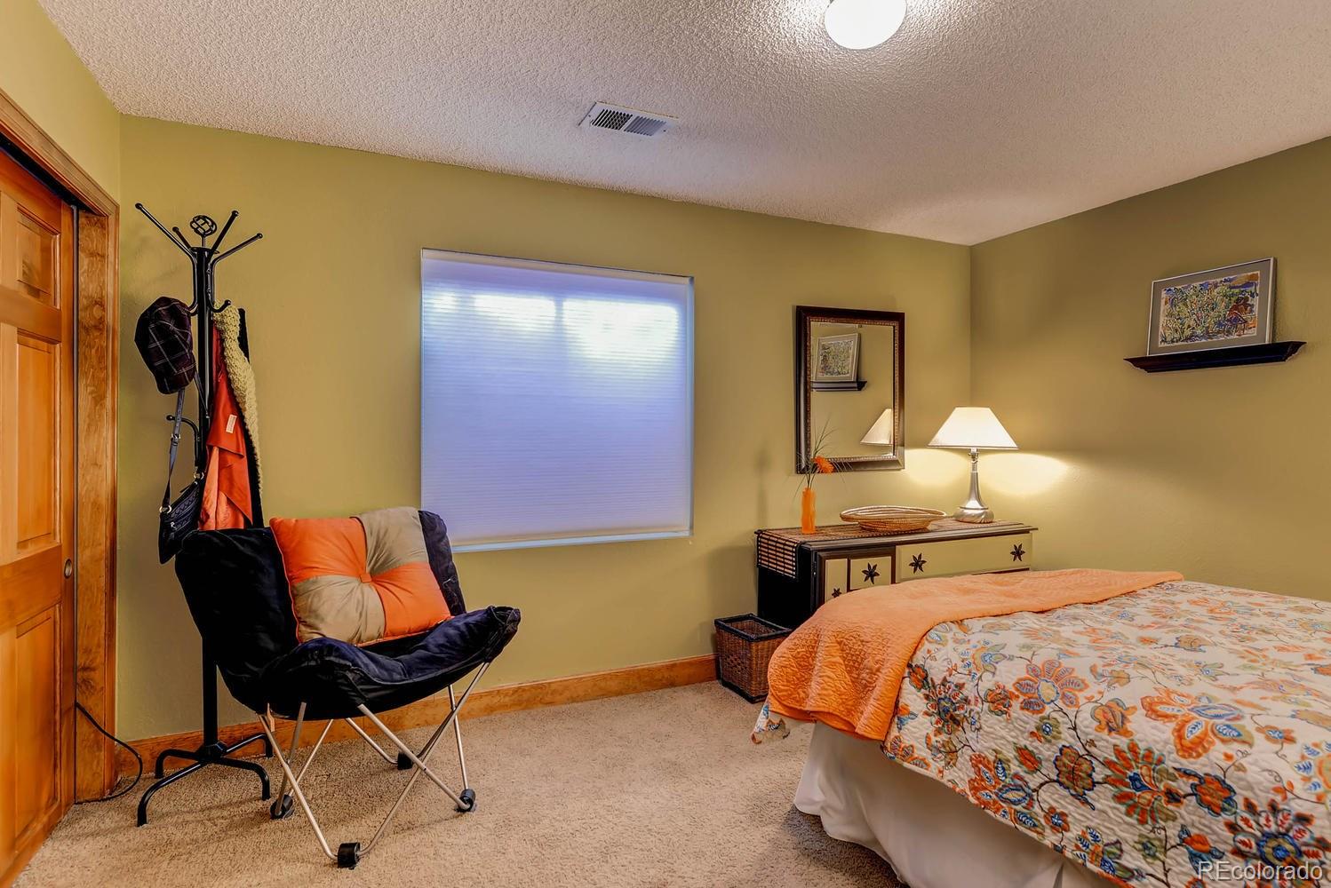 8110 Sweet Water Road Lone Tree, CO 80124 - Photo 26 of 34 a bedroom with a bed and chair