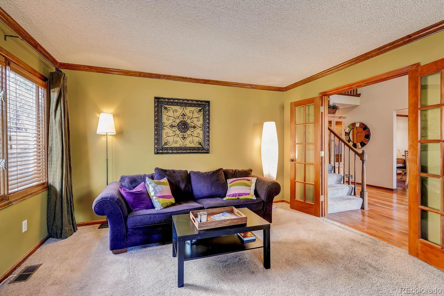 8110 Sweet Water Road Lone Tree, CO 80124 - Photo 10 of 34 a living room with furniture and a painting on the wall