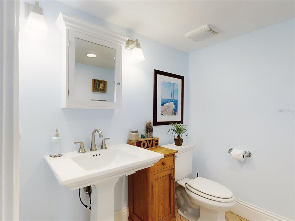 1913 Hill Street, Unit 2 New Smyrna Beach, FL 32169 - Photo 25 of 90 a bathroom with a toilet a sink and mirror