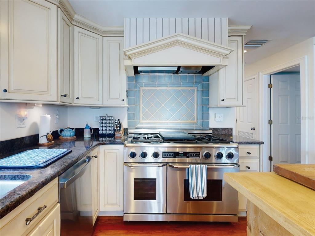 1913 Hill Street, Unit 2 New Smyrna Beach, FL 32169 - Photo 32 of 90 a kitchen with granite countertop a sink a stove and cabinets